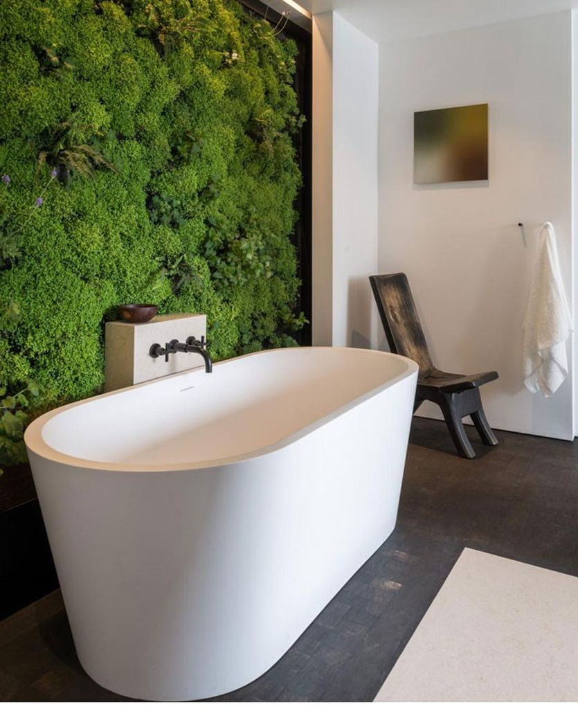 Modern bathroom design with white tub and white wall combined with moss on the wall to perfect your bathroom design