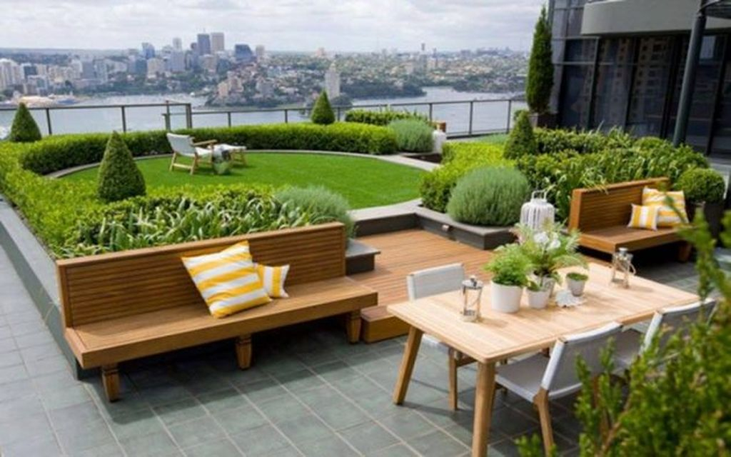 Modern large rooftop projects with wooden seating combined with plants around it to perfect your rooftop garden