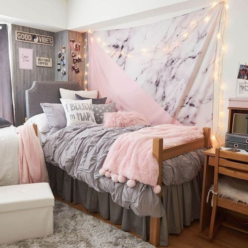 Small girls room decor with a gray bed combined with a small pink blanket, gray and white pillows, string lights to complement the decor