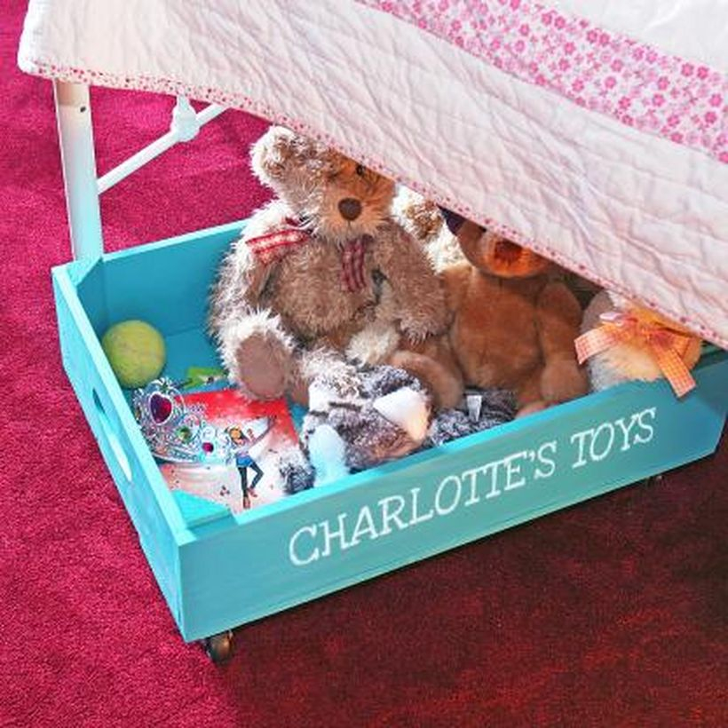 Small square storage for children toy with blue color and have wheels under the bed