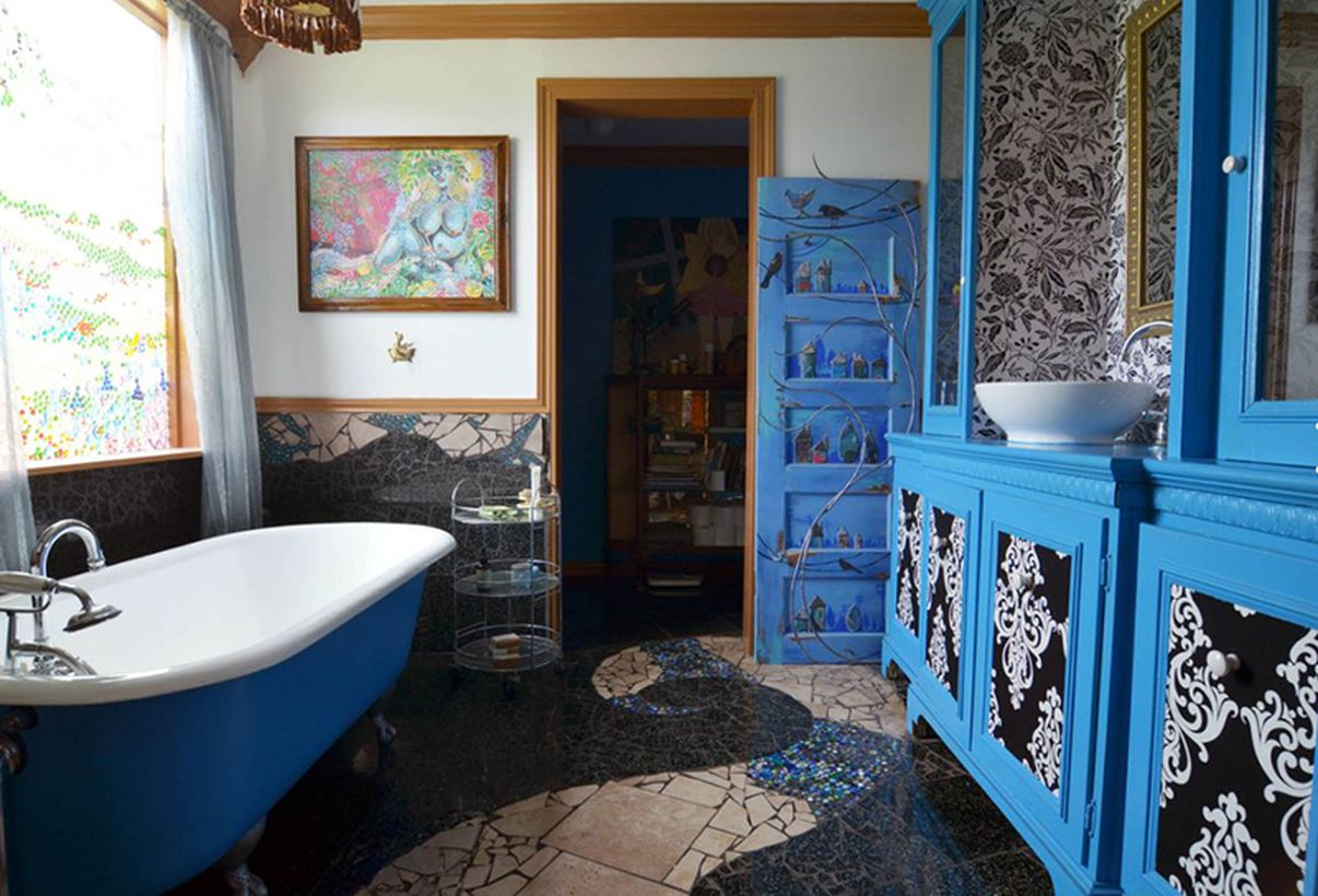 Unique boho bathroom decor with patterned tiles, blue wood storage and white and blue bathtub to look amazing