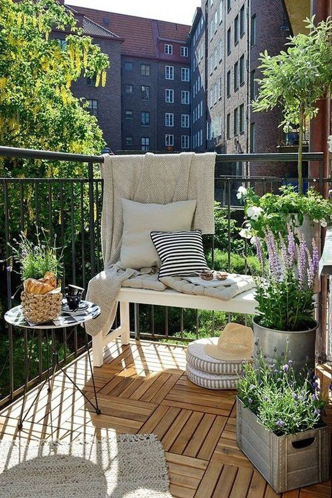 Wooden floor and round table combined with plants decoratin for small balcony