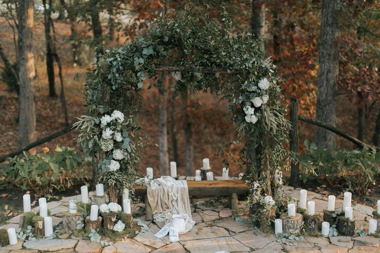 An elegant take on rustic wedding style with arrangement candle, greenery, flowers, and a hint of moss