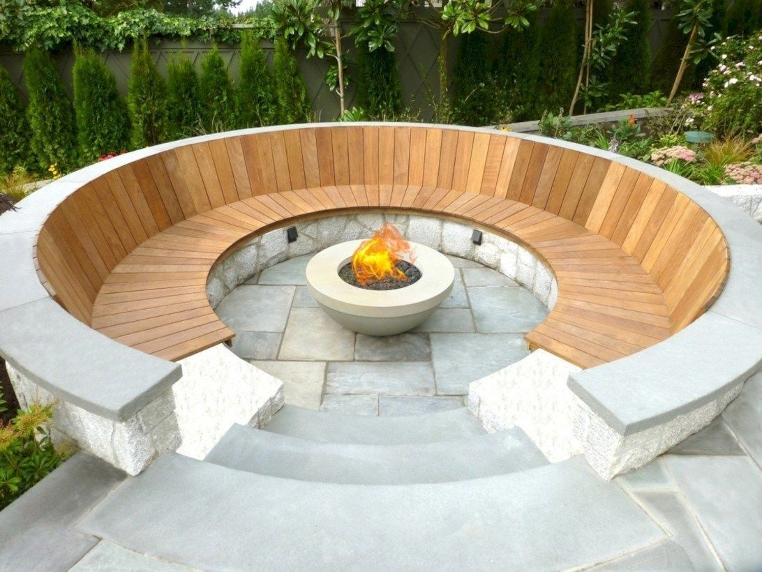 Outdoor curved fire pit with wooden pallet for sitting
