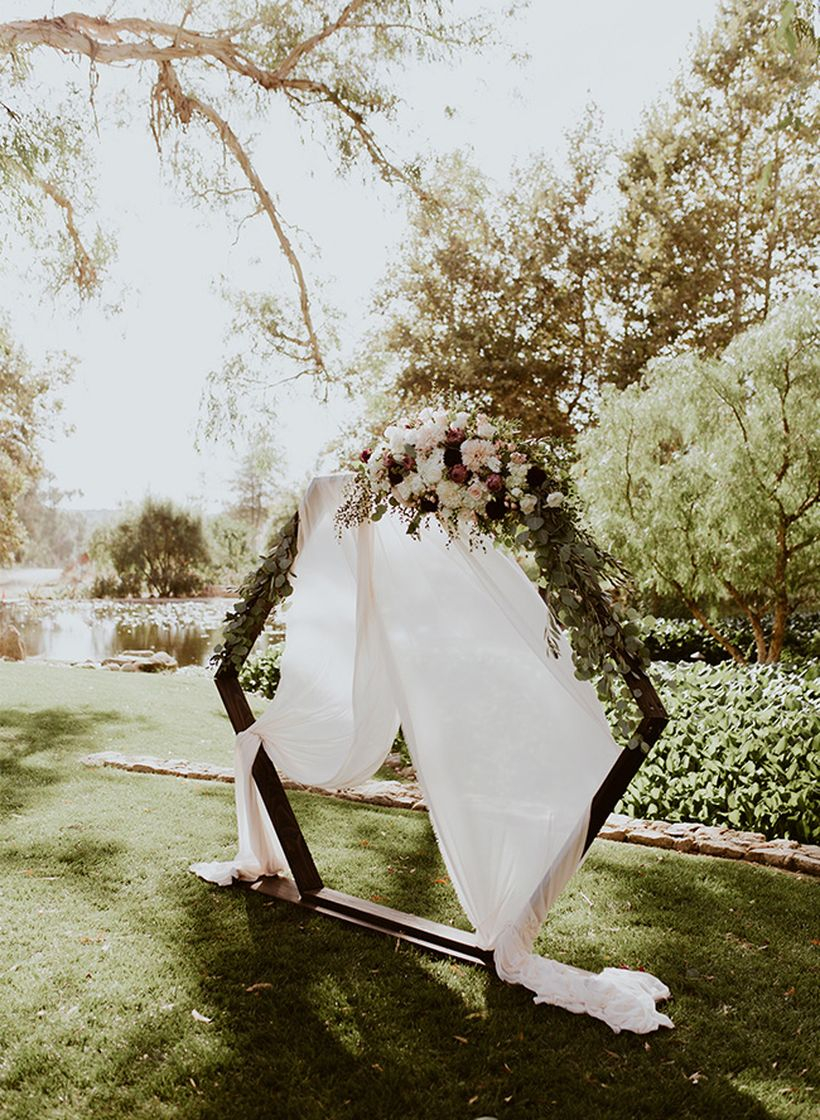 Romantic and moody geometric inspired wedding with backdrop shape hexagon from wooden and add floral to create beautify