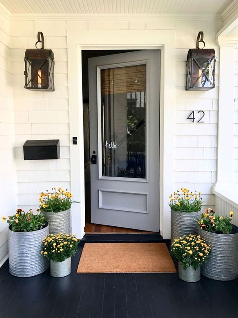 Simple front door decoration with galvanized planters and blooming plants to create a cozy the porch