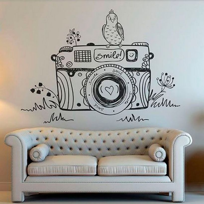 Small white living decor with wall painting unique camera theme on the wall