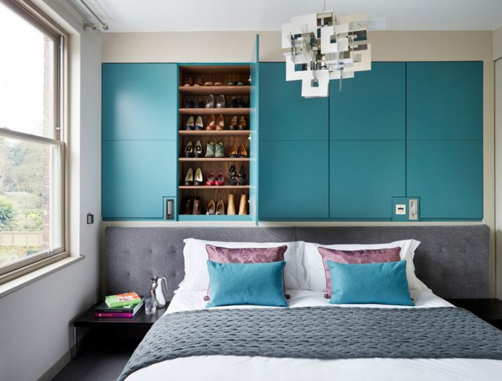 An amazing shoes storage idea for a small bedroom with shelves above the headboard to organize your shoes storage