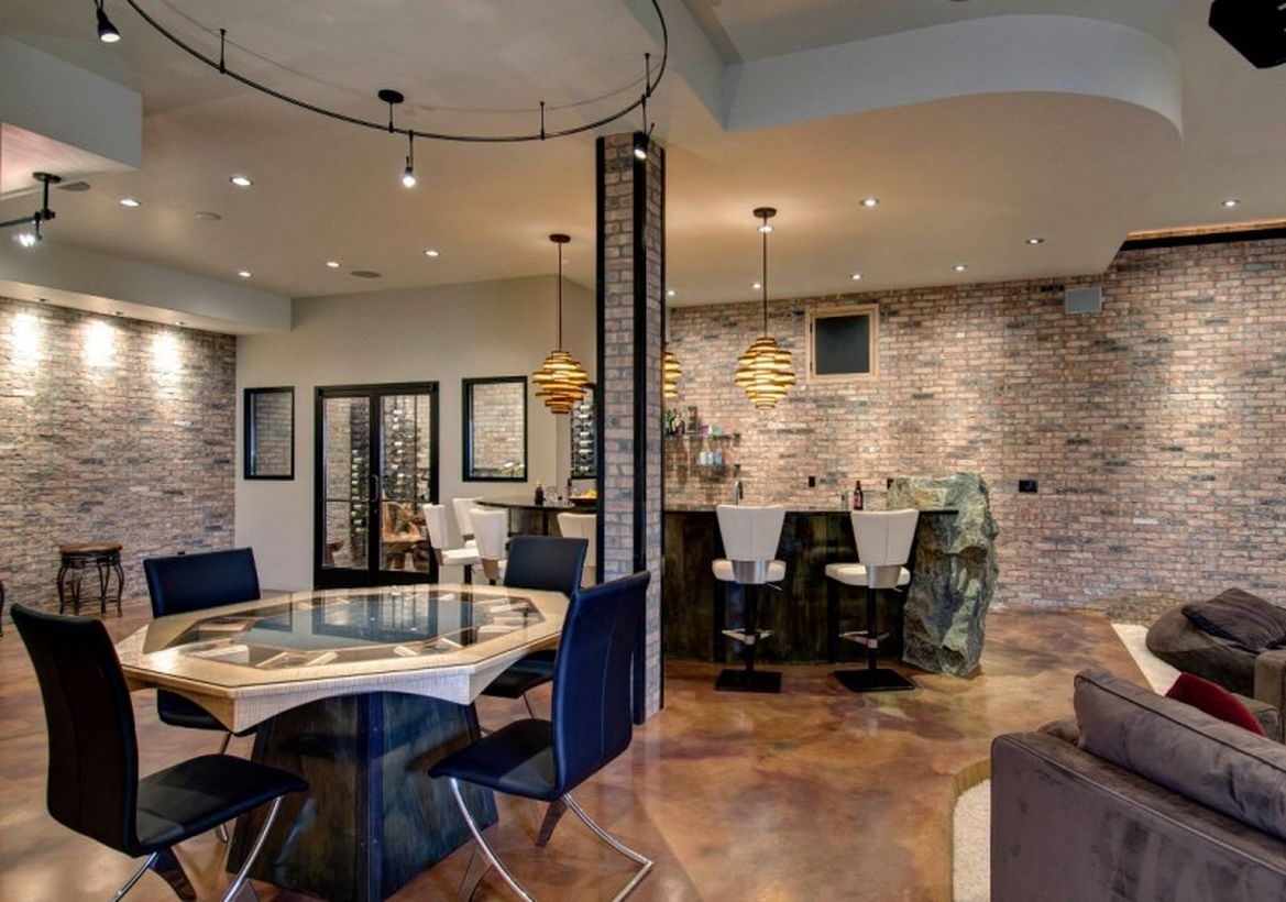 Basement with stone bar, roun white table, black chairs and unique hanging lamps