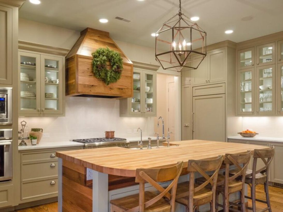 Beautiful kitchen with unique candle lamp, wooden island table and wooden chairs to look awesome