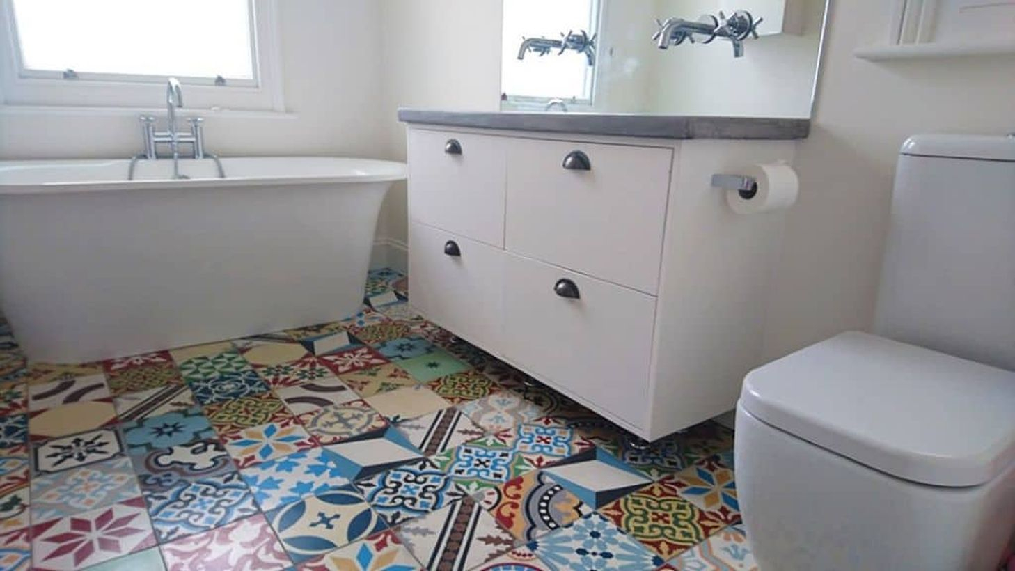 Creative bathroom with white fixtures and colorful patchwork tiles for smart decoration