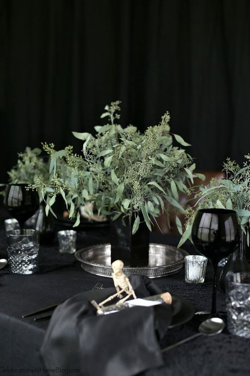 Creepy dining table with dark theme and small human skeleton ornament