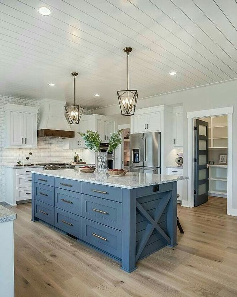Faboush kichen with blue and white island table, white cabinet, wooden floor and hanging candle lamps