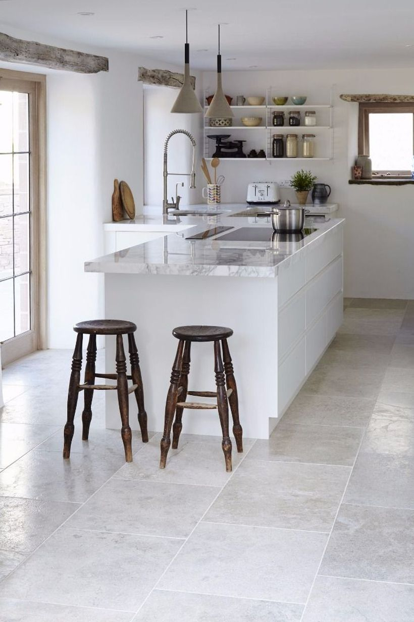 Gray brushed limestone kitchen floor tiles with white island table and small wooden chairs ideas
