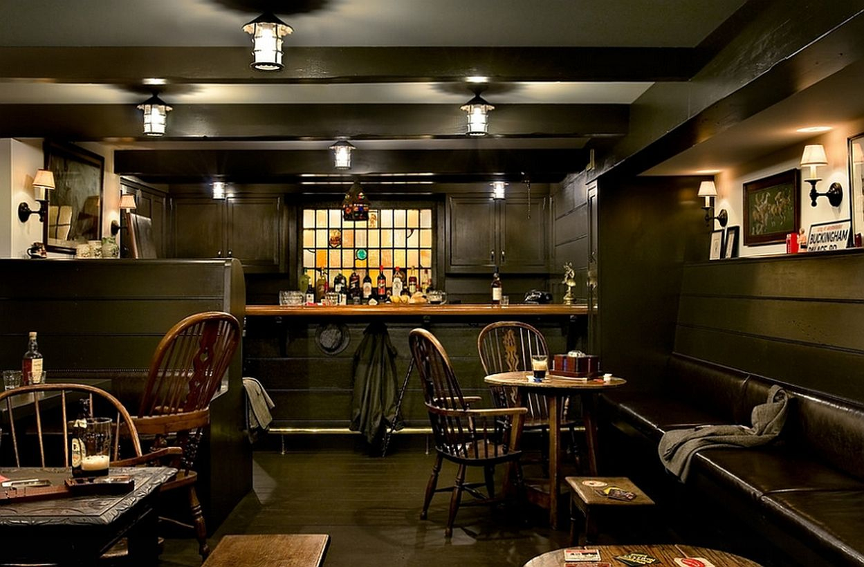 Green basement with bar, wooden chairs and green walls