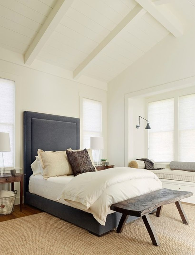Impresiv bedroom with blue bedstead, white bed, white walls and square wooden chairs