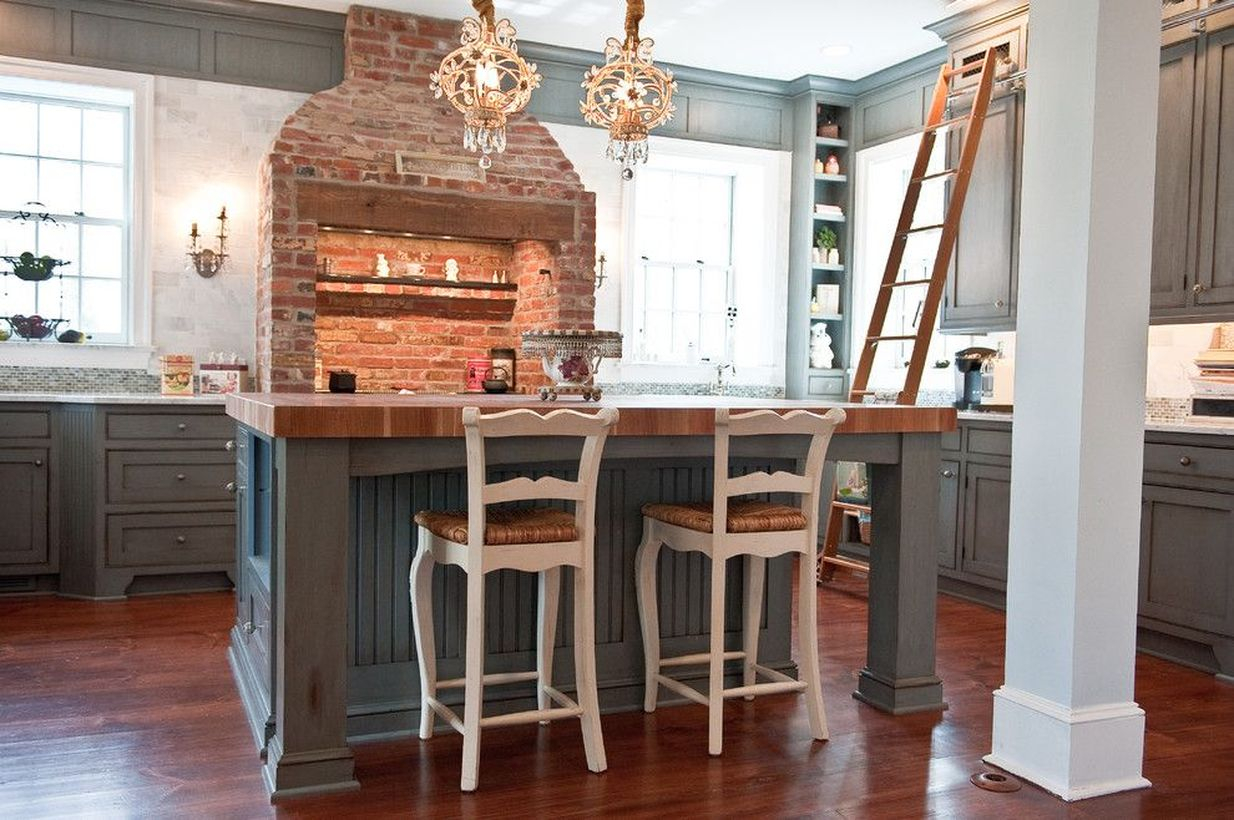 Simple wooden kitchen flooring with gray cabinet, gray wooden island table and brick cooker hood