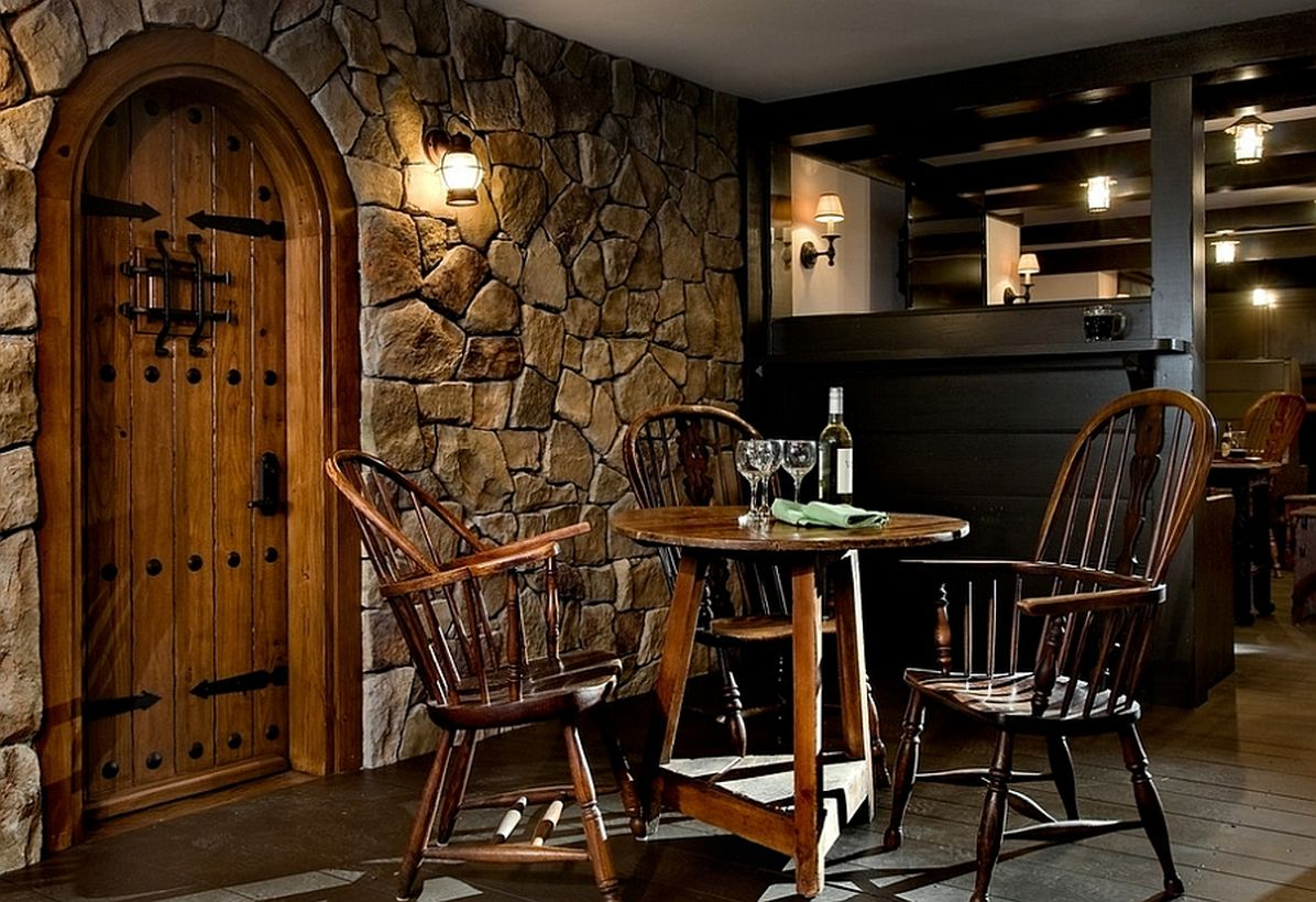 Basement makeove with stone wall, iron, and wooden chairs