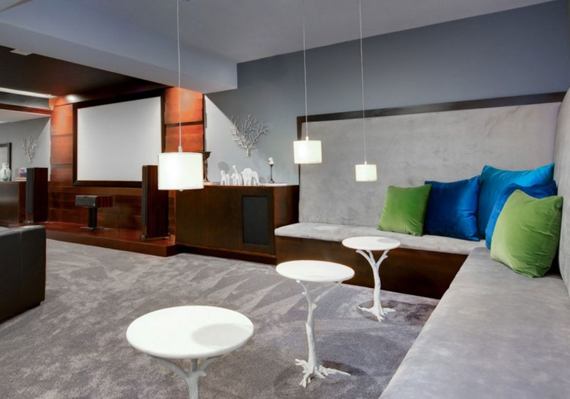 Basement with small hanging lamps, smal round white table and gray carpet