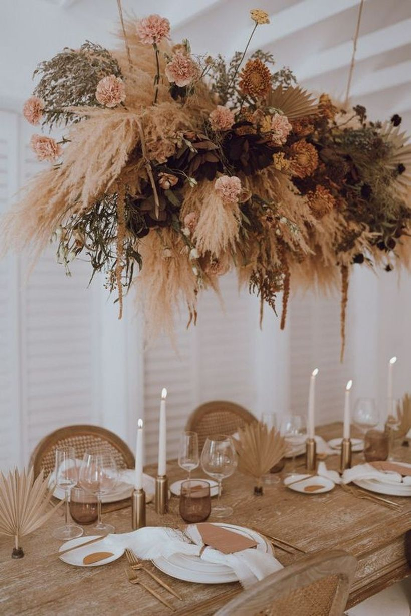 Boho table with black napkins and candles, wicker chargers, geometric touches, dried florals and pampas grass