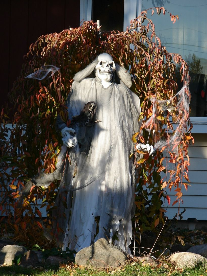 Outdoor halloween decoration creepy with a corpse character behind a tree