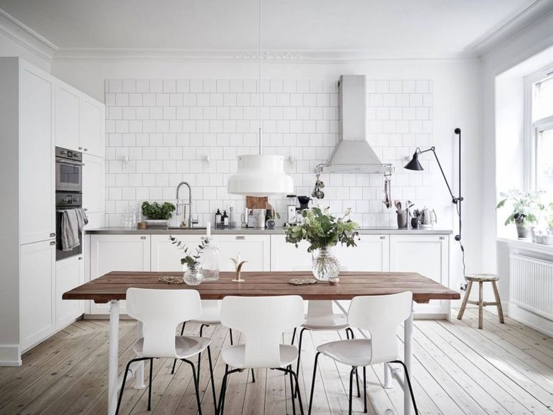 Scandinavian kitchen flooring with white cabinet, wooden table, white chairs and white walls
