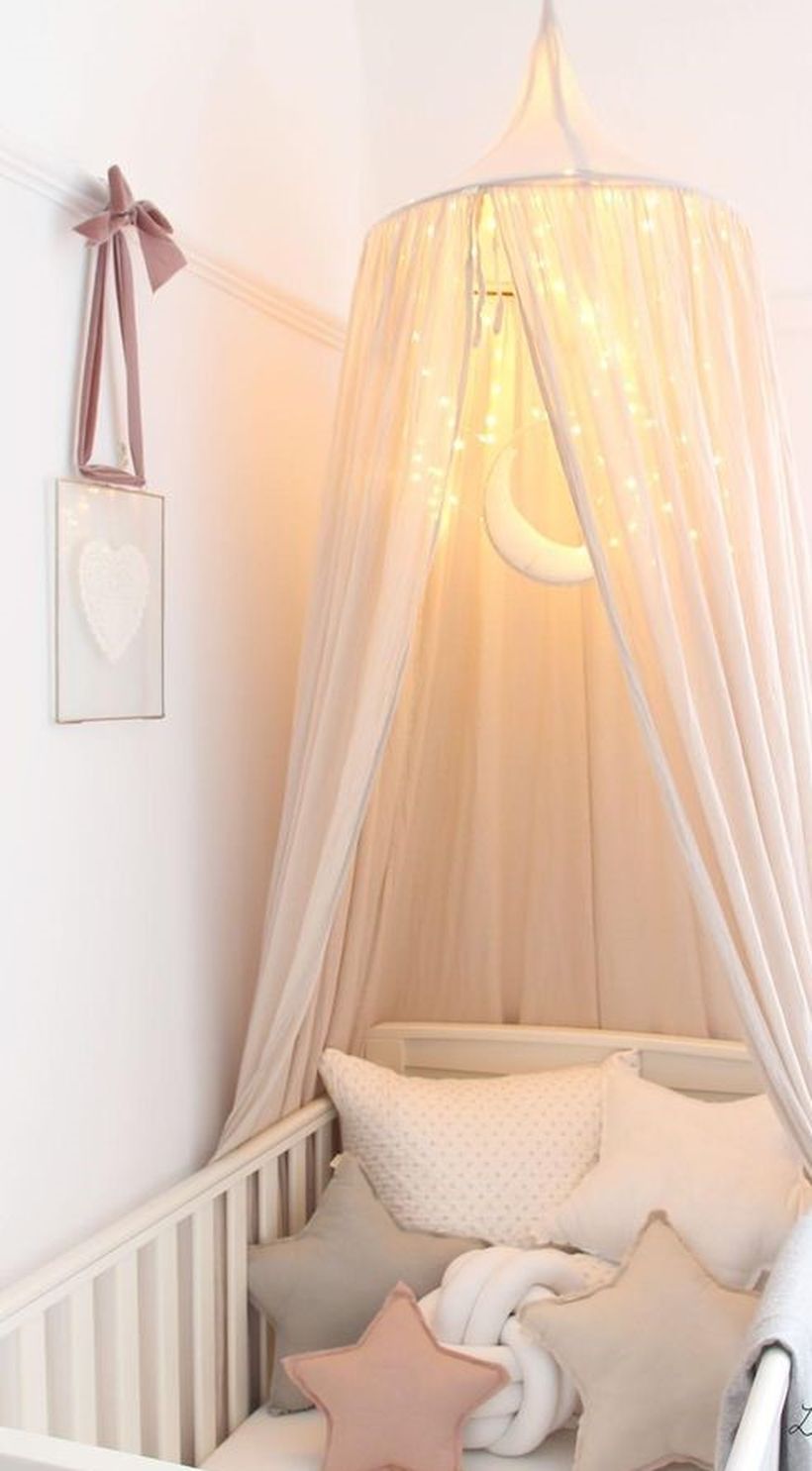 White-dreamy-baby-girls-nursery-room-with-hanging-baby-mosquito-nets-and-decorative-lighting-like-the-moon-and-stars