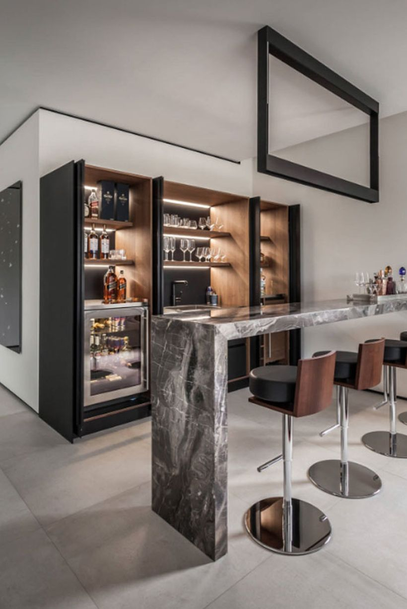 Black coffee bar combined with lights inside, a black and white table and small sofa chairs