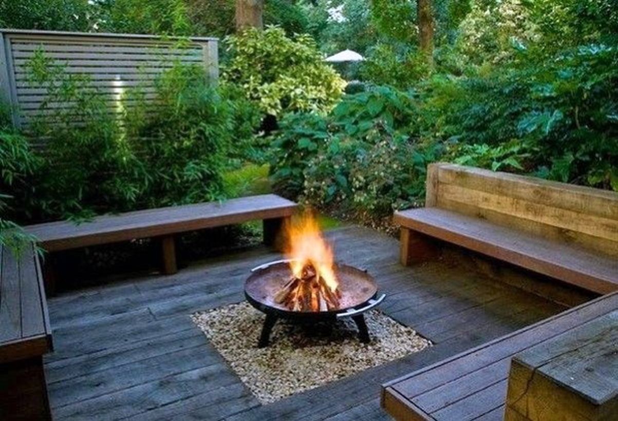 Diy-fire-pit-at-the-bottom-is-given-a-white-gravel-and-square-wooden-bech-in-your-backyard-patio-deck
