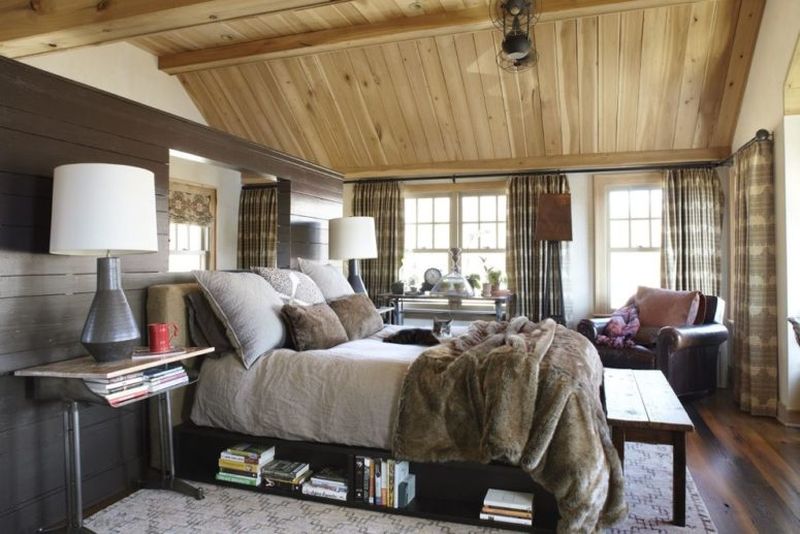 Farmhouse-bedroom-with-much-wood-printed-curtains-and-a-bed.-1