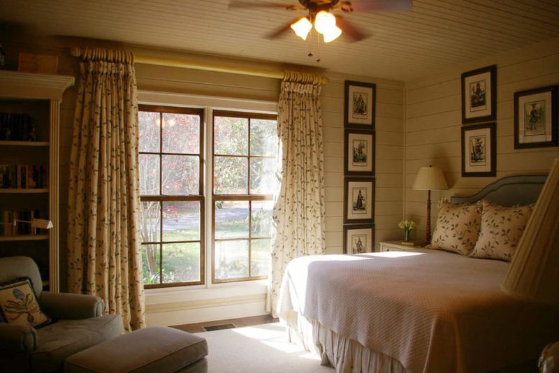 Farmhouse-bedroom-with-printed-textiles-and-many-artworks.-1