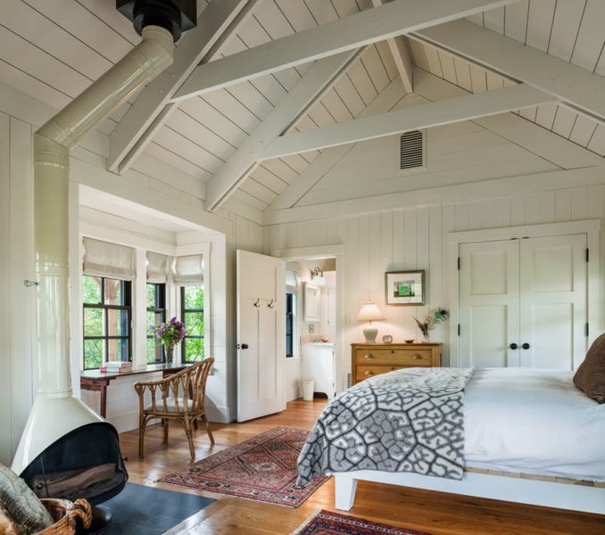 Farmhouse-bedroom-with-window-and-ceiling-beams.-1