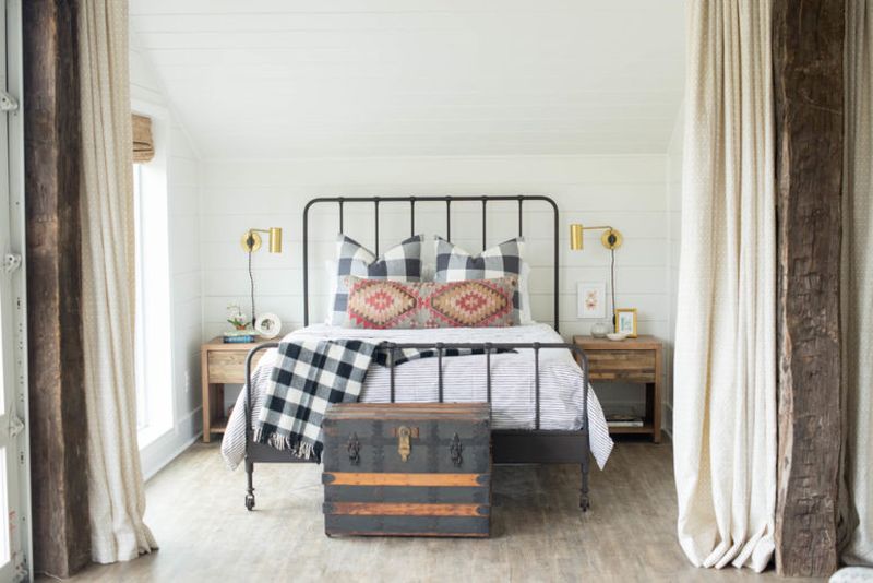 Farmhouse-bedroom-with-wooden-nightstands-a-forged-bed.-1