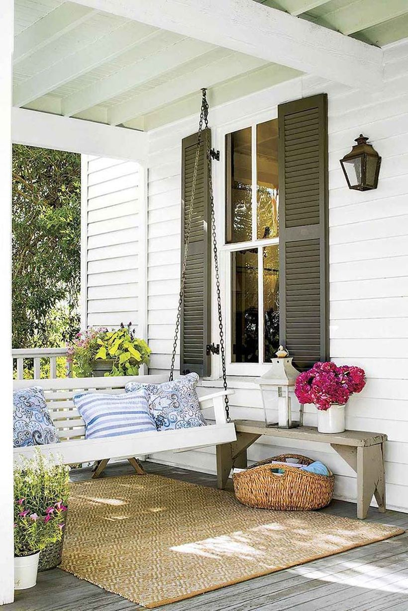 High-ceiled front porch idea decor with white swing bed