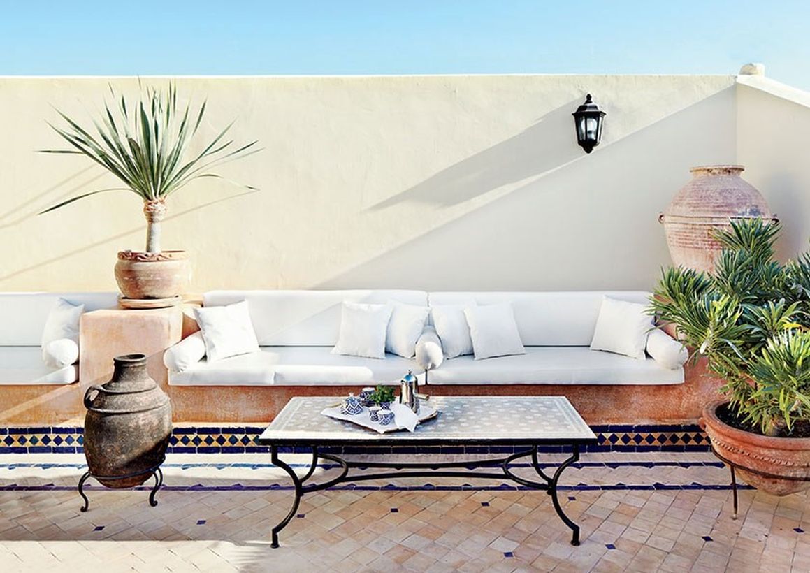 Rustic-seating-rooftop-area-with-a-long-white-sofa-and-classic-coffee-table-plus-plants-to-create-a-cool-atmosphere