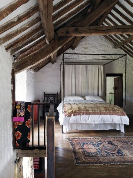 Stone-walls-and-wooden-beams-a-large-metal-bed-and-boho-rugs.-1