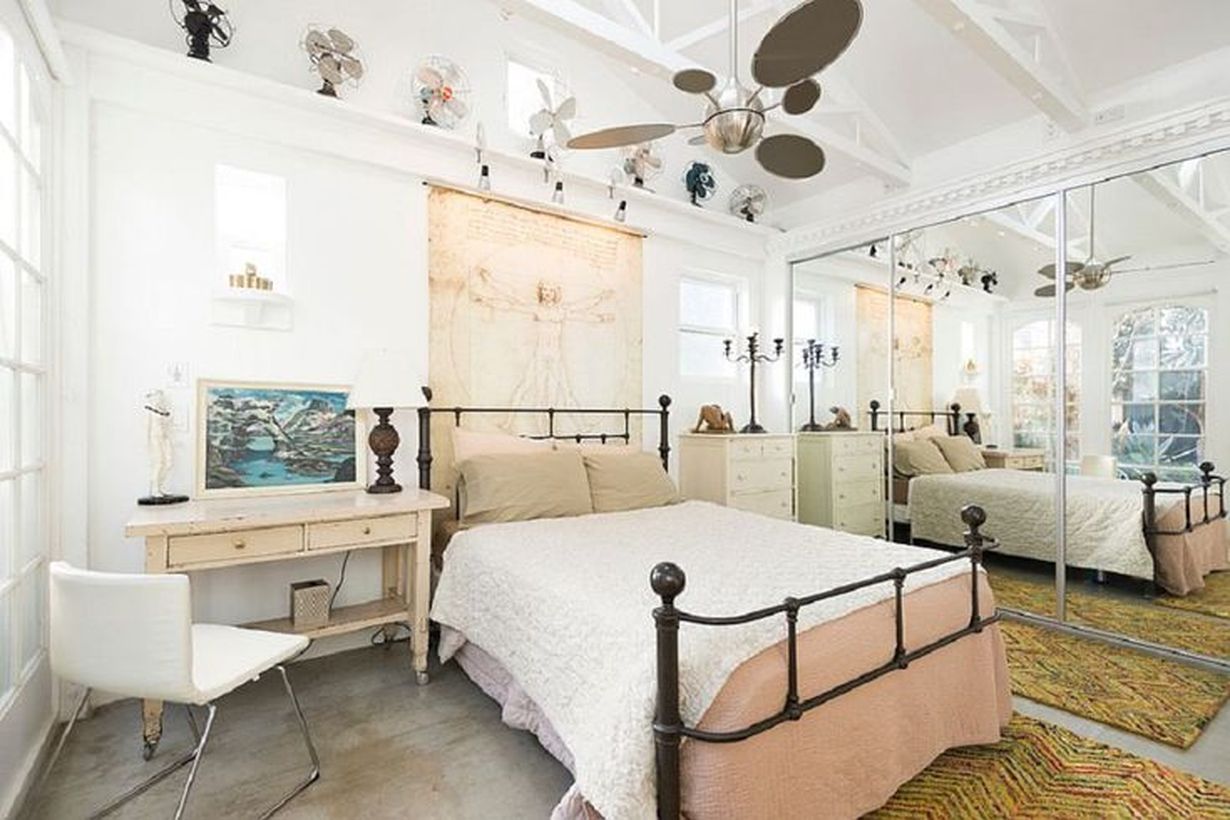 Black-iron-frame-bed-and-wooden-white-nightstand-yang-menghiasi-your-bedroom-with-hanging-rack-to-store-classic-fan-and-classic-table-lamp-menciptakan-suasana-vintage