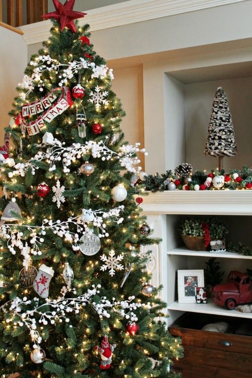 Green-christmas-tree-with-various-ornaments-such-as-bell-ornament-socks-ornament-and-merry-christmas-greeting-from-paper