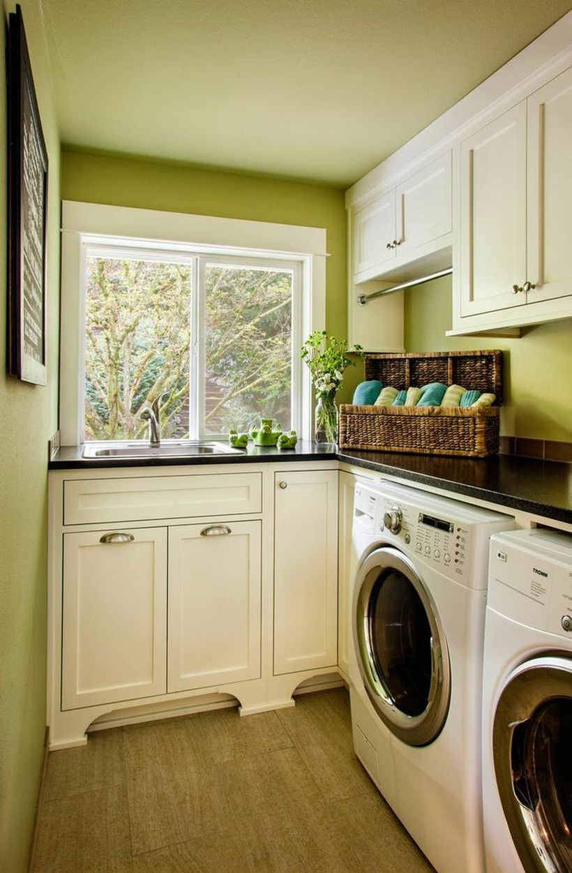 Laundry room with white cabinet and green walls