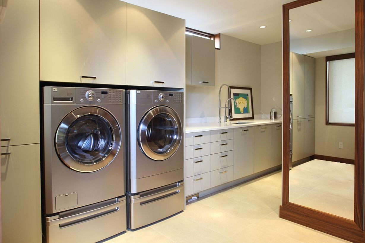 Laundry room with white cabinet and silver washing machine