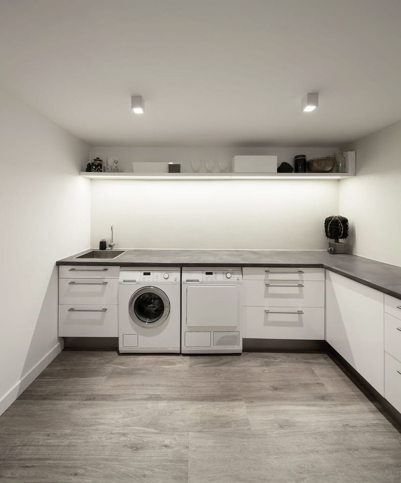 Laundry room with white cabinet and white rack
