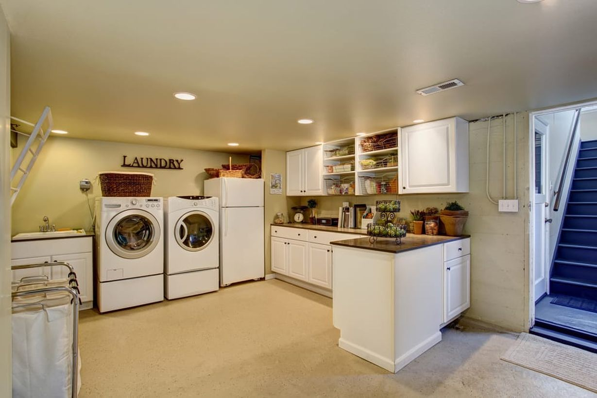 Laundry room with white cabinet and white washing machine