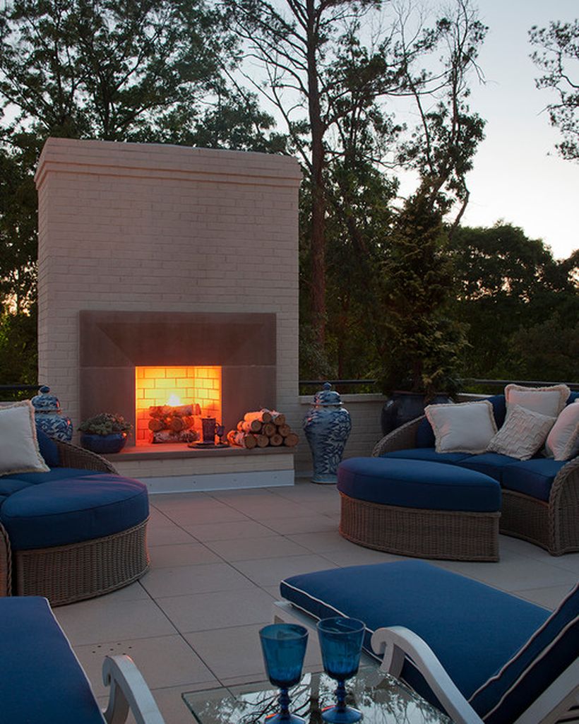 Modern-fire-pit-design-in-your-rooftop-with-the-position-of-the-blue-sofa-and-rattan-frame-to-warm-you-up-at-night