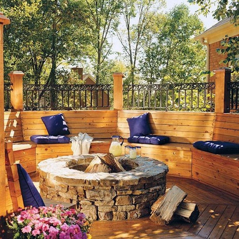 Nice-patio-deck-with-natural-stone-fire-pit-and-curved-wooden-bench-with-sofa-cushion-for-comfortable-sitting