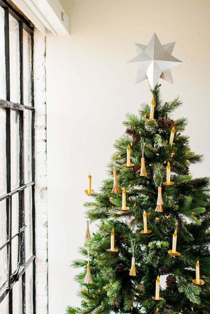 Paper-candle-that-was-hung-on-the-green-christmas-tree-as-an-ornament-that-adorns-the-tree-and-the-top-big-star-for-additional-ornament