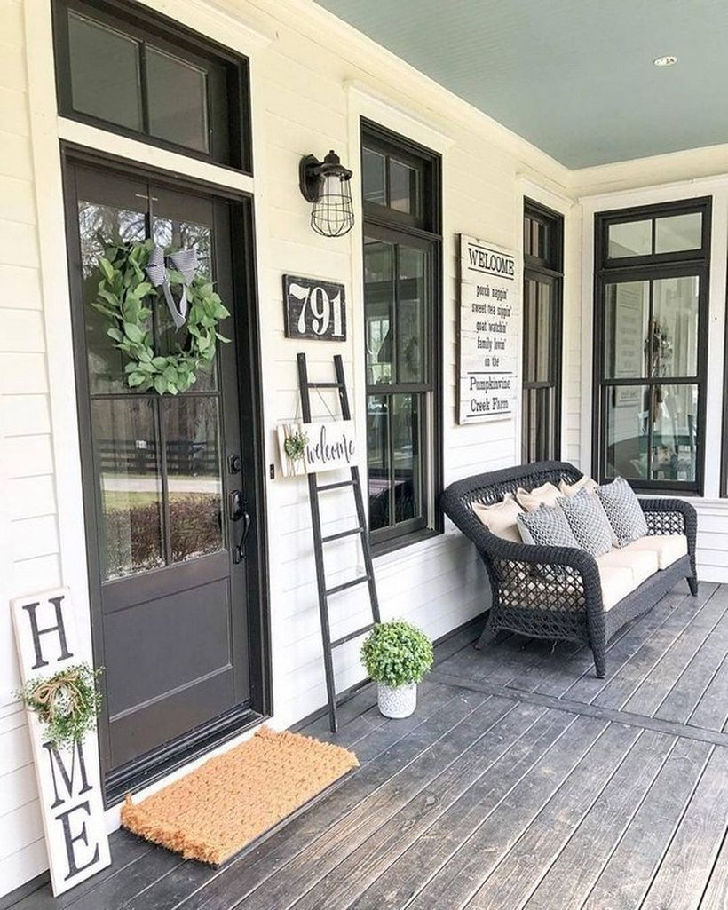 Proch with black rattan chair and small plant