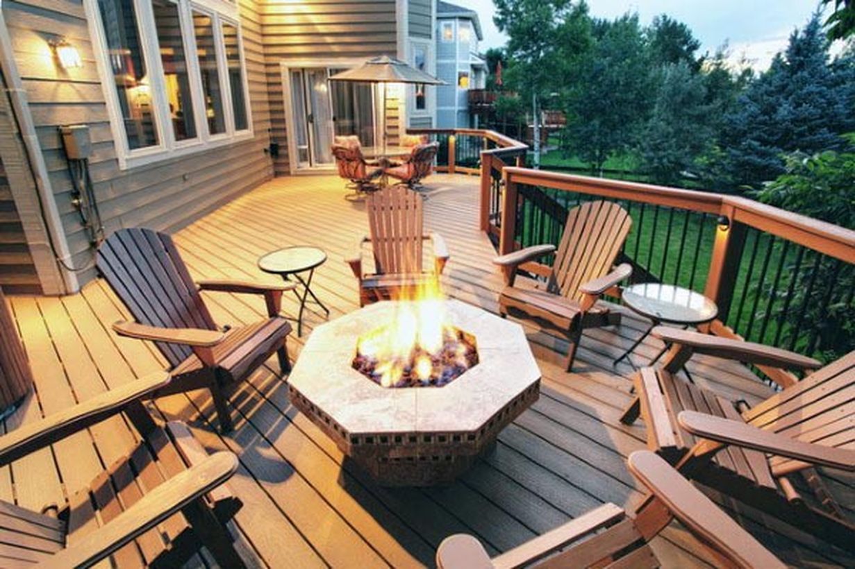 Simple-backyard-patio-deck-design-with-a-unique-hexagon-shaped-fire-pit-wooden-chair-and-coffee-table-to-relax-and-warm-the-body