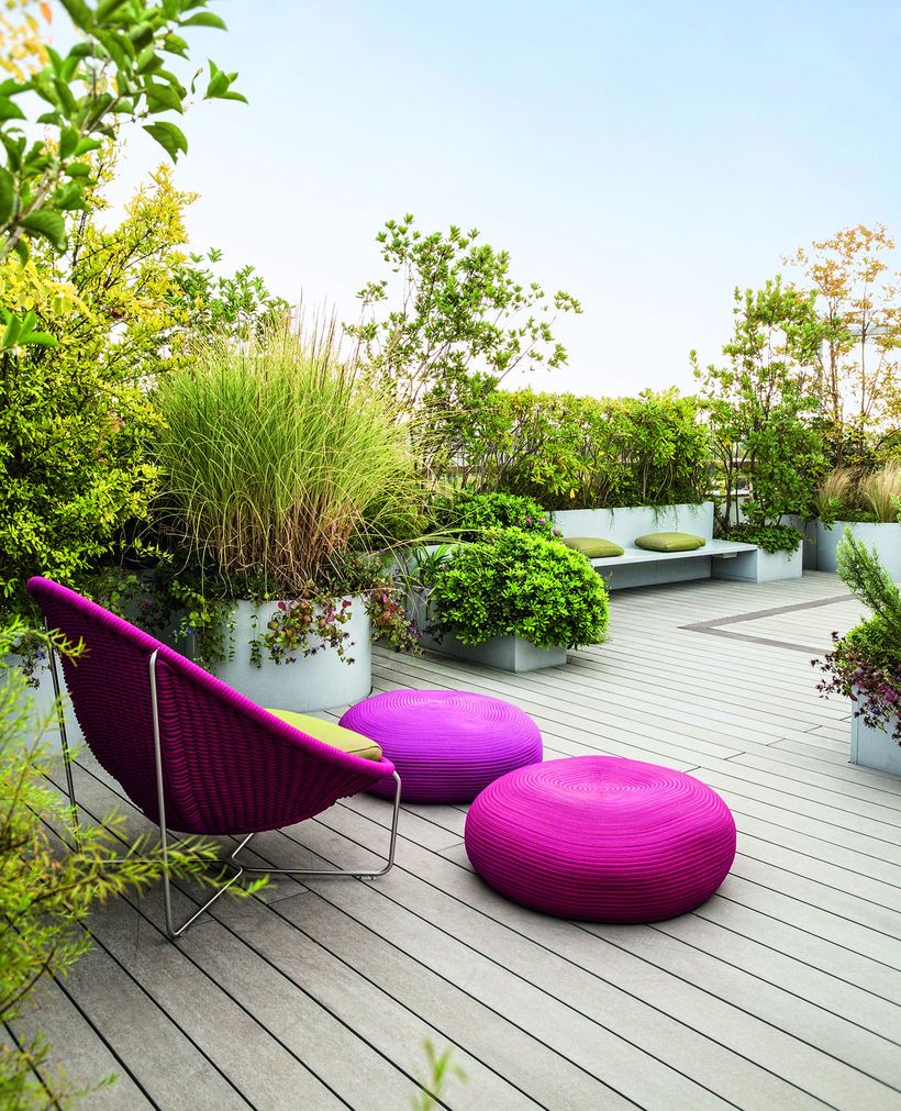 Smart-garden-arrangement-with-fresh-greenery-on-the-rooftop-and-red-lounge-chairs-to-relax