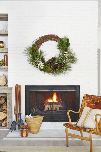 A-simple-wreath-of-pinecones-fresh-greenery-and-a-few-white-flowers-makes-a-versatile-piece-you-can-showcase-above-a-fireplace-all-winter-long.