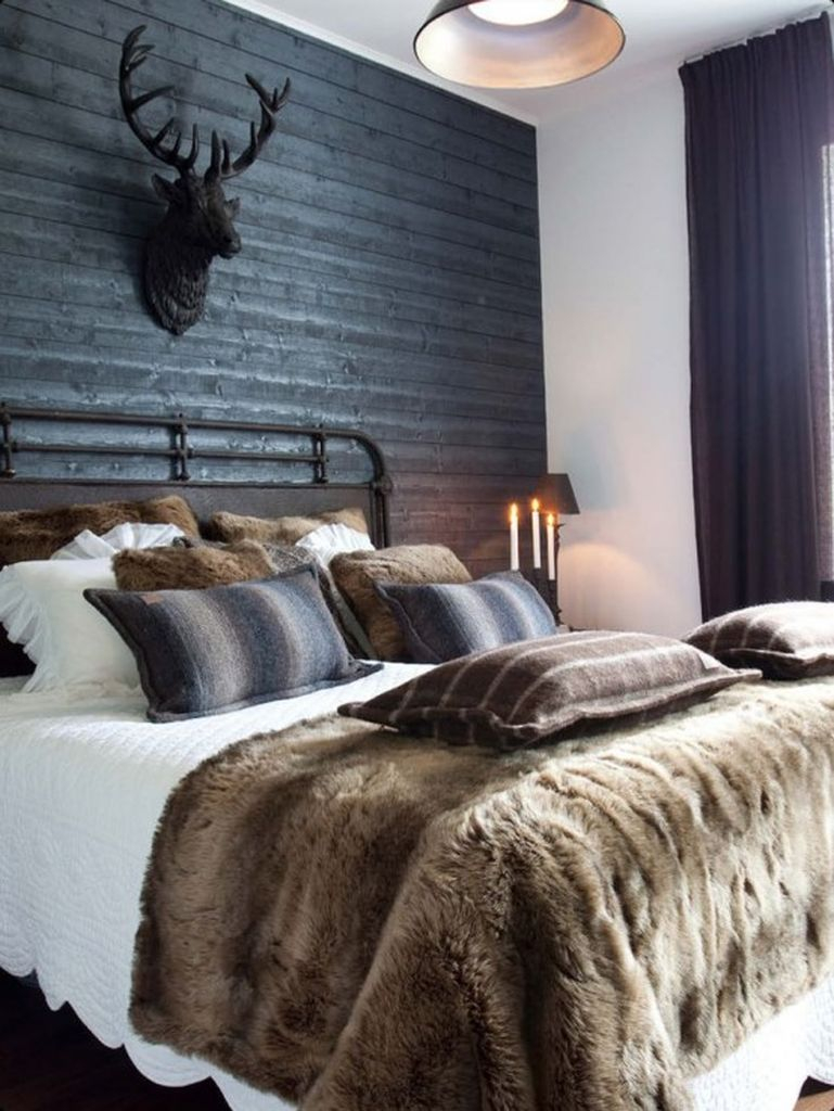 Bedroom with a black wooden wall, dark textiles